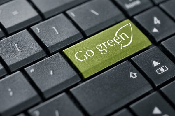 Photo vue du dessus d'un clavier d'ordinateur avec des touches noires et une touche verte où il est inscrit « Go green ».