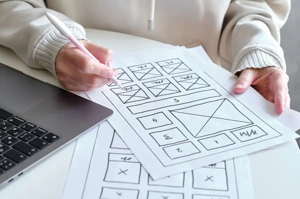 Une femme travaille sur les wireframe d'une landing page