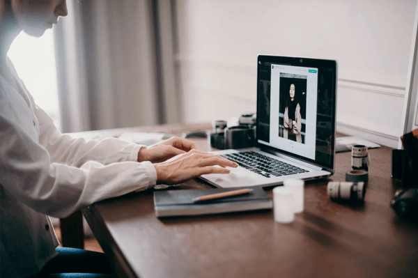 Sur cette photo, une femme écrit sur son ordinateur.